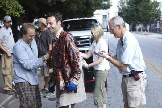 Behind the scenes: Andrew Lincoln has laugh while the prop crew prep his bloody, gutty coat.